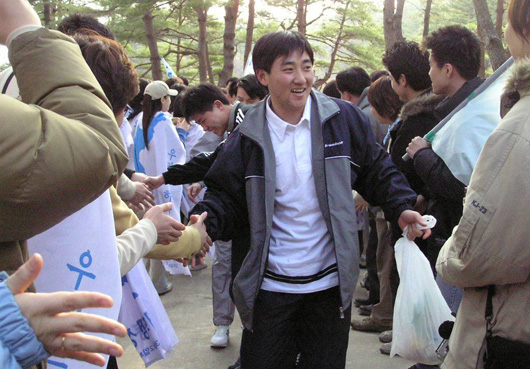 삼일포에 먼저 도착한 남쪽 대학생들이 뒤따라 온 북쪽 참가단에게 손을 내밀어 악수를 청하고 있다..남녀 없이 음식을 담은 비닐봉지를 들고 나온 북쪽 대학생들의 모습이 이채롭다 